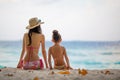 Mother and daughter in bikini sit on beach Royalty Free Stock Photo