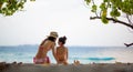 Mother and daughter in bikini sit on beach Royalty Free Stock Photo