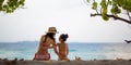 Mother and daughter in bikini sit on beach Royalty Free Stock Photo