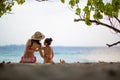 Mother and daughter in bikini sit on beach Royalty Free Stock Photo