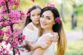 Mother and daughter in the blooming rose gardens of Apple trees. Happy motherhood. Beautiful family Royalty Free Stock Photo