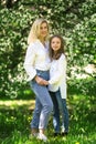 Mother and daughter in the blooming rose gardens of Apple trees. Happy motherhood. Beautiful family portrait Royalty Free Stock Photo