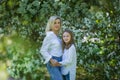 Mother and daughter in the blooming rose gardens of Apple trees. Happy motherhood. Beautiful family portrait Royalty Free Stock Photo