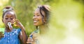 Mother and daughter blowing bubbles with blurry green transition Royalty Free Stock Photo
