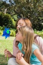 Mother with daughter blowing pinwheel in the park Royalty Free Stock Photo