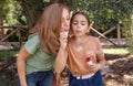 Mother and daughter blowing soap bubbles in a park Royalty Free Stock Photo