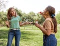 Mother and daughter blowing soap bubbles in a park Royalty Free Stock Photo