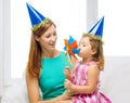 Mother and daughter in blue hats with pinwheel Royalty Free Stock Photo