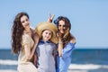 Mother daughter and a boy in a straw hat messing around.