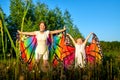 Mother and daughter with bright fabric like butterfly wings play, fly, run, jump in meadow or field with green grass and dandelion Royalty Free Stock Photo