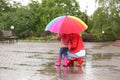 Mother and daughter with bright umbrella under rain Royalty Free Stock Photo