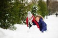 Mother with daughter build a snowman in park.