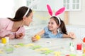 Mother and daughter with bunny ears headbands painting Easter egg Royalty Free Stock Photo