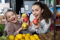 Mother and daughter buying apples in shop