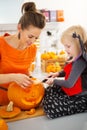 Mother with daughter carving Jack-O-Lantern for Halloween party Royalty Free Stock Photo