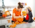 Mother with daughter carving Jack-O-Lantern for Halloween party Royalty Free Stock Photo