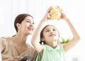 Mother and daughter checking the piggy bank for her future savings Royalty Free Stock Photo