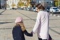 Mother and daughter child hold hands, walk and talk on the city street, view from the back Royalty Free Stock Photo