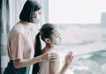 Mother with daughter child in mask looking from window Royalty Free Stock Photo