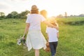 Mother and daughter child walking along the meadow, view from the back Royalty Free Stock Photo