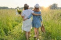 Mother and daughter child walking along the meadow, view from the back Royalty Free Stock Photo