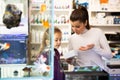 Mother with daughter choosing aquarium accessories in pet shop Royalty Free Stock Photo