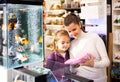 Mother with daughter choosing aquarium accessories in pet shop Royalty Free Stock Photo