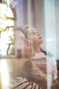 Mother and daughter in a church prying in a catechism education session. Christianity and catholicism concept and empty copy space Royalty Free Stock Photo