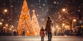 A mother and daughter at the city looking at a lit Christmas tree, snowy evening, winter season, holidays