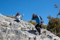 Mother and daughter climb and rest on cliff