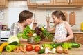 Mother and daughter cook and taste soup from vegetables. Home kitchen interior. Parent and child, woman and girl. Healthy food con