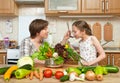 Mother and daughter cook and taste soup from vegetables. Home kitchen interior. Parent and child, woman and girl. Healthy food con Royalty Free Stock Photo
