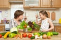 Mother and daughter cook and taste soup from vegetables. Home kitchen interior. Parent and child, woman and girl. Healthy food con Royalty Free Stock Photo