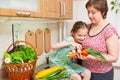 Mother and daughter cooking. Basket of vegetables and fresh fruits in kitchen interior. Parent and child. Healthy food concept Royalty Free Stock Photo