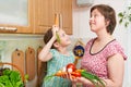 Mother and daughter cooking. Basket of vegetables and fresh fruits in kitchen interior. Parent and child. Healthy food concept Royalty Free Stock Photo