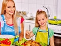 Mother and daughter cooking at kitchen