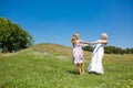 Mother and daughter dancing in a meadow.