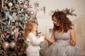 Mother and daughter decorate a Christmas tree.