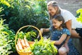 Mother And Daughter Digging In Raised Vegetable Beds At Home