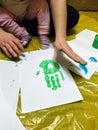 Mother and daughter do handprints with green paint Royalty Free Stock Photo