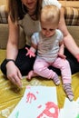 Mother and daughter do handprints with red paint Royalty Free Stock Photo