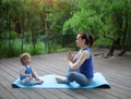 Mother and daughter doing exercise practicing yoga outdoors Royalty Free Stock Photo