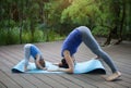 Mother and daughter doing exercise practicing yoga outdoors Royalty Free Stock Photo