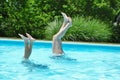 Mother and daughter doing handstands in the pool Royalty Free Stock Photo