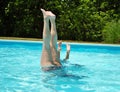 Mother and daughter doing handstands in the pool Royalty Free Stock Photo