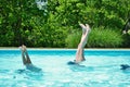 Mother and daughter doing handstands in the pool Royalty Free Stock Photo