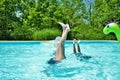 Mother and daughter doing handstands in the pool Royalty Free Stock Photo