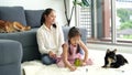 Mother and daughter are doing homework in the living room with Shiba Inu.