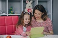 Mother and daughter doing homework online. Distance learning online education. Schoolgirl with digital tablet laptop Royalty Free Stock Photo