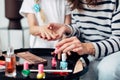 Mother and daughter doing manicure at home, painting nails with nail polish